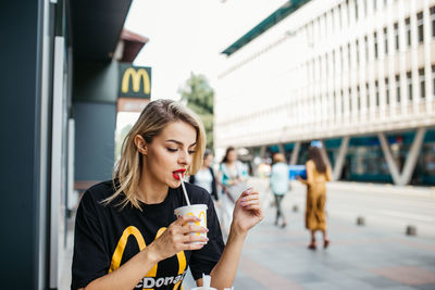 Young woman drinking coffee in city