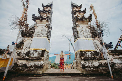 Young woman standing at temple gate