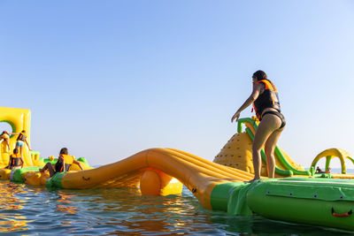 Inflatable bounce castle floats in park for children having fun in water with attractions in the sea