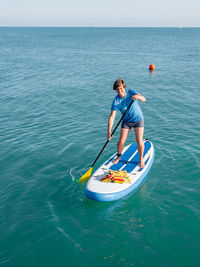 Handsome paddle boarder. sportsman paddling on stand up paddleboard. sup surfing. active lifestyle. 