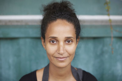 Portrait of young female gardener smiling at yard