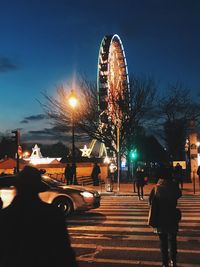 Illuminated ferris wheel in city at night