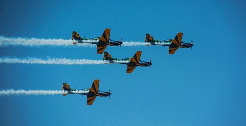 Low angle view of airplane flying against blue sky