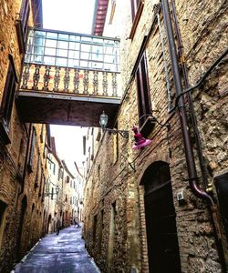 Low angle view of narrow alley amidst buildings