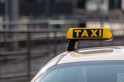 Taxi with yellow sign on roof on a shiny day waiting for passengers and tourists to drive to airport