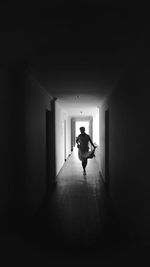 Rear view of silhouette man walking in building