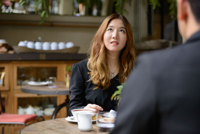 Portrait of a young woman with coffee cup in restaurant