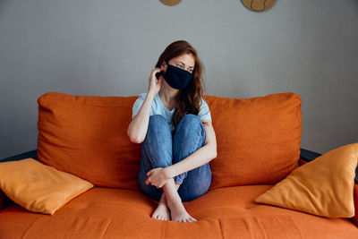 Woman sitting on sofa at home