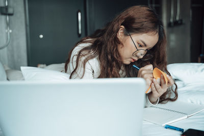 Woman using mobile phone while sitting on table