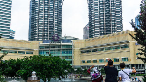 People by modern buildings in city