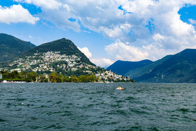 Scenic view of sea by mountains against sky