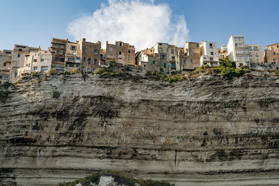 View on the old town of bonifacio from boat on the cliffs, low angle view of old ruins against sky