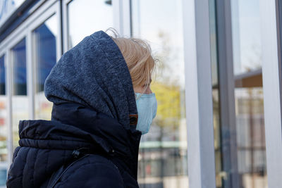 Side view of woman standing in snow