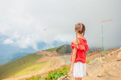 Full length of woman standing on mountain against sky