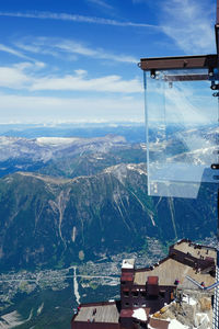 Aerial view of townscape by mountain against sky