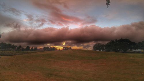 Scenic view of field against cloudy sky