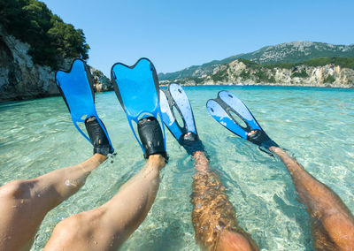 Low section of people swimming in sea