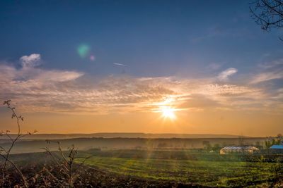 Scenic view of field against sky during sunset