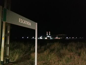 View of illuminated sign against clear sky at night