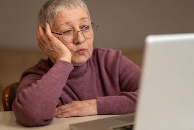 Portrait of senior man using laptop on table