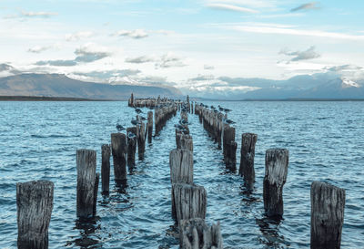 Wooden pier over sea against sky