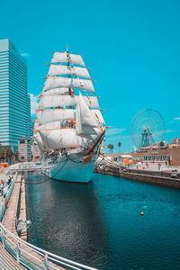 Ferris wheel in city against clear blue sky