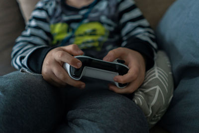 Midsection of man using mobile phone