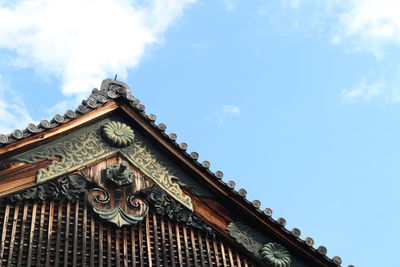 Low angle view of traditional house against cloudy sky