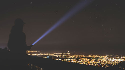 Illuminated city against sky at night