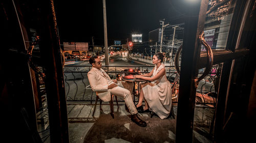 People sitting on chair in city at night