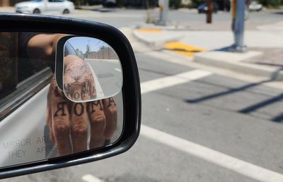 Reflection of road on side-view mirror of car