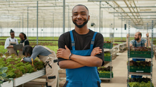 Portrait of young man standing in greenhouse