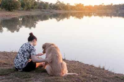 Side view of man with dog on lake