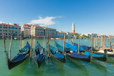 Boats moored in canal against buildings