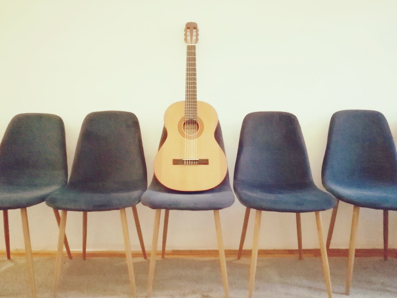 EMPTY CHAIRS AND TABLE AGAINST WALL IN ROOM