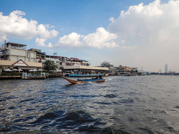 Scenic view of sea by buildings against sky