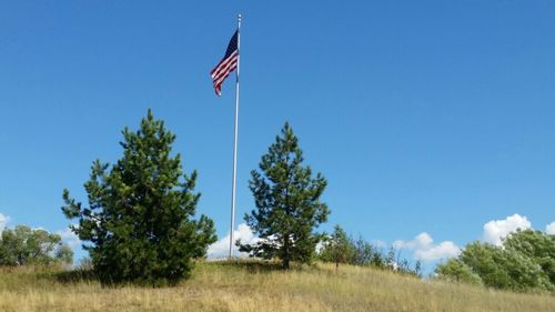 Low angle view of american flag against clear blue sky