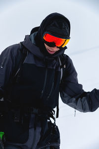 Portrait of a skier in safe ski equipment, standing and relaxing smiling while on vacation on the