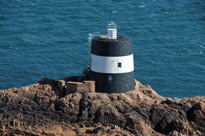 Lighthouse on rock by sea