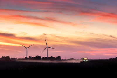 Tractor harvesting a field at sunset on a iowa farm