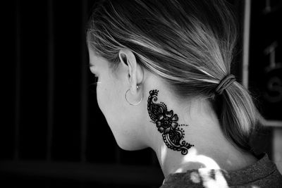 Close-up of teenage girl with tattoo on neck