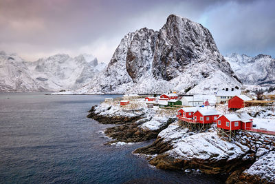 Scenic view of sea and snowcapped mountains against sky