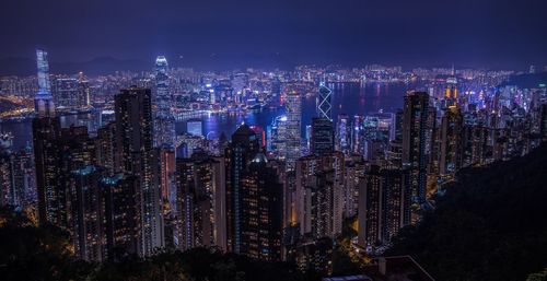 Illuminated cityscape against sky at night