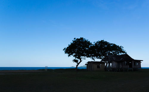 House on field against clear sky