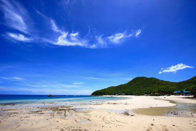 Scenic view of beach against blue sky