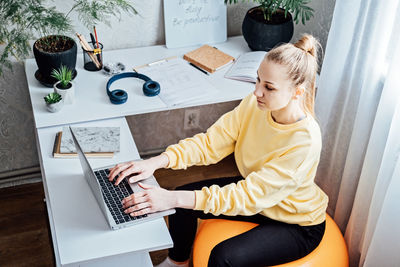 Sitting on gym ball at work. use exercise ball like chair at workplace. freelancer woman sitting on