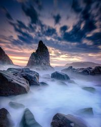 Scenic view of rocks against sky during sunset