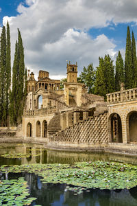 Arch bridge over lake against buildings