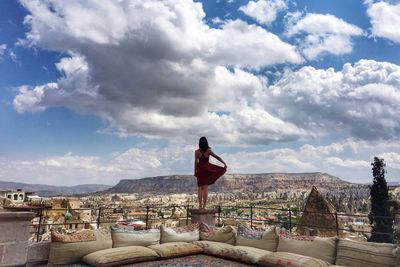 Woman looking at city against sky