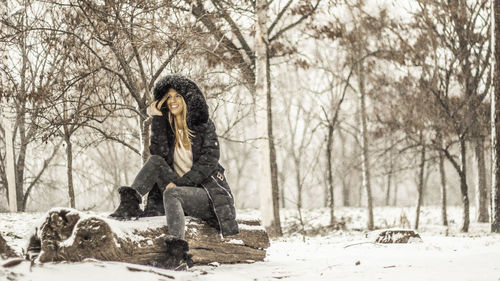 Portrait of woman sitting on snow covered land